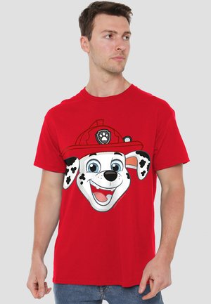 Red cotton t-shirt featuring a large graphic of a cartoon dog with a firefighter hat, black spots, and blue eyes. Classic crew neck design.
