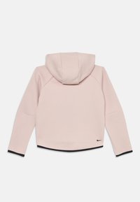 Sweatshirt rosa com capuz, apresentando mangas raglan, uma barra preta e um simples logótipo da Nike. A textura parece suave e macia.