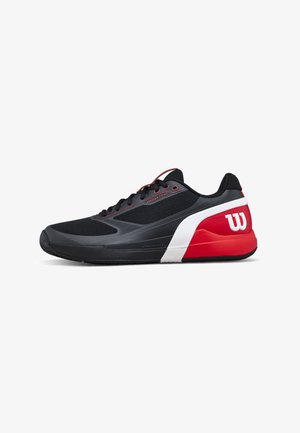 Chaussure de sport noire, rouge et blanche avec lacets, semelle amortie et logo "W" au talon, conçue pour le sport ou la course.