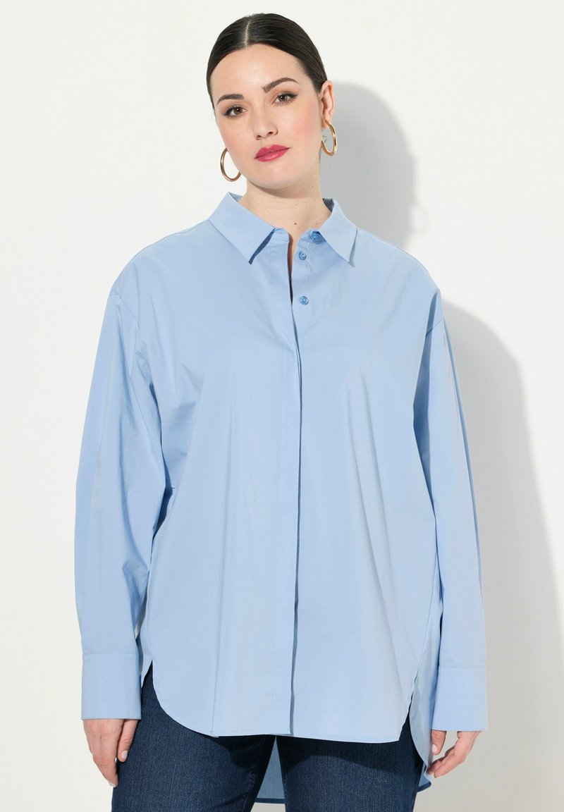 Camicia azzurra a maniche lunghe con colletto, caratterizzata da una vestibilità rilassata, fessure laterali e tessuto di cotone morbido.