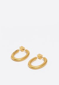 Pendientes de aro de oro con un acabado liso y brillante. Forma curva y única con un cierre de pitorro cilíndrico. Sin patrones ni acentos visibles.