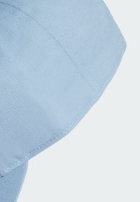 Casquette en coton bleu clair avec un design structuré, présentant des coutures visibles et une surface texturée. Visière légèrement courbée.