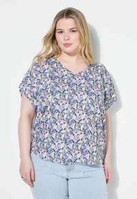 Top con stampa floreale in morbido tessuto. Caratterizzato da scollo a V, maniche corte e una vestibilità rilassata. I colori prevalenti sono blu navy, giallo, rosa e bianco.