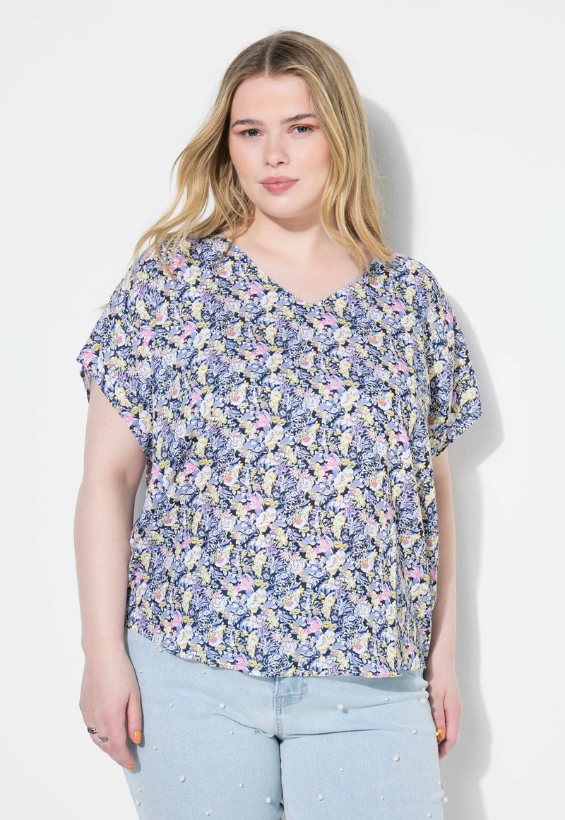 Top con stampa floreale in morbido tessuto. Caratterizzato da scollo a V, maniche corte e una vestibilità rilassata. I colori prevalenti sono blu navy, giallo, rosa e bianco.
