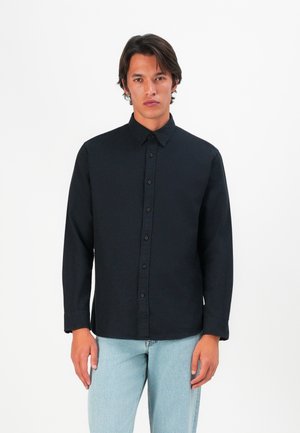 Zwarte lange mouwen shirt met een button-down kraag, voorste knopen en een gladde textuur, gecombineerd met lichtblauwe jeans.