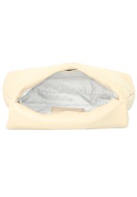 Borsa in pelle crema con una texture morbida, aperta per rivelare un interno foderato in argento che presenta un sottile motivo geometrico e un'etichetta del marchio.