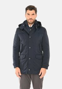 Parka con cappuccio di colore blu navy con zip e bottoni frontali, due tasche anteriori e polsini regolabili. Tessuto liscio con una vestibilità su misura.