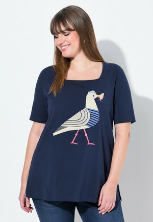 T-shirt bleu marine à manches courtes, avec un graphique d'un oiseau à motif rayé et des accents roses. Encolure carrée.