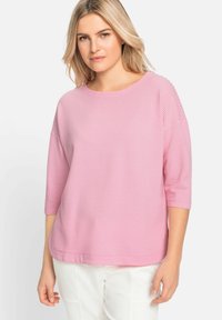 Rosa und weiße kariertes Oberteil mit rundem Ausschnitt und Dreiviertelärmel, aus weichem, strukturiertem Stoff hergestellt. Leicht und locker sitzend.