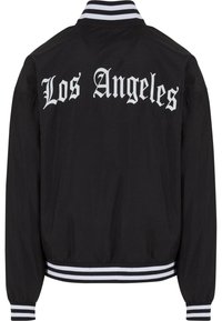 Svart bomberjacka med vit text "Los Angeles", randiga manschetter och nederkant. Tillverkad av ett glatt, lättviktsmaterial.
