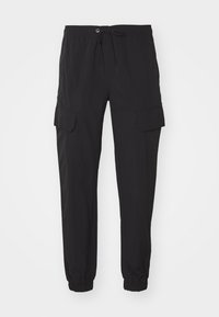 Zwarte cargobroek met een elastische tailleband, trekkoord en twee zijker pockets. Gemaakt van lichtgewicht stof met taps toelopende boorden.