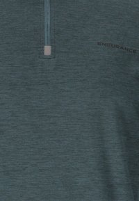 Teal, korte mouw sporttop met een ritskraag, gemaakt van gestructureerde, ademende stof. Voorzien van het "ENDURANCE" logo aan de voorkant.