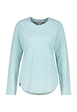 Chemise bleu clair à manches longues avec encolure ronde, ourlet incurvé et petite étiquette noire sur le côté inférieur, présentée sur fond blanc.