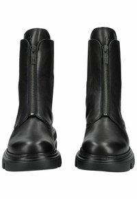 Botas negras de cuero hasta el tobillo con una textura suave, que cuentan con una cremallera frontal y una suela de goma gruesa. El diseño de la bota es elegante y con acentos mínimos.