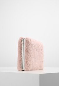 Rosa fodrad clutch i rektangulär form, med silverdetaljer på kanten. Mjuk textur med en minimalistik design.