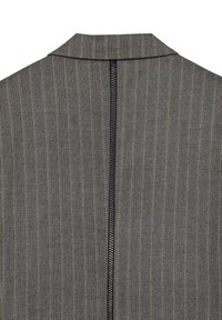Tessuto grigio a motivo spina di pesce con colletto alto e zip nera centrale sul retro. La texture è intrecciata e strutturata.