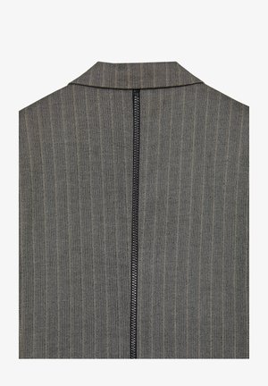 Tessuto grigio a motivo spina di pesce con colletto alto e zip nera centrale sul retro. La texture è intrecciata e strutturata.