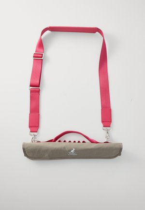 Sac en tissu gris avec une bandoulière rose, présentant un design plat, une poignée et des ferrures en métal. Comprend un logo à l'avant.