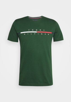 Grøn bomulds-T-shirt med korte ærmer, der har teksten "TOMMY HILFIGER" i hvid, med horisontale røde og marineblå detaljer.