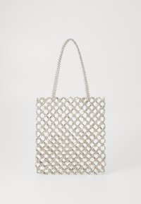 Silver mesh tote bag featuring a geometric, lattice design with a beaded handle. Open weave allows visibility of contents.