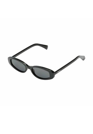 Lunettes de soleil ovales noires avec verres solides foncés et branches droites, inclinées légèrement vers le haut sur fond blanc.