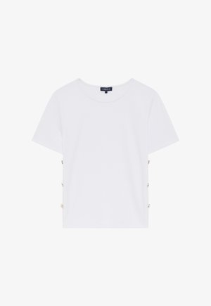Witte katoenen t-shirt met korte mouwen, voorzien van een ronde halslijn en decoratieve knopen in goudkleur aan de zijkant voor extra detail.