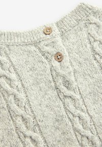 Pull en tricot gris avec un motif de torsades texturé, comportant un col côtelé et deux boutons en bois à l'encolure.