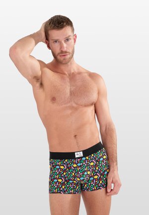 Boxer-Shorts mit schwarzem Grund, die ein lebhaftes abstraktes Mosaikmuster in Gelb, Pink, Grün und Blau zeigen. Schwarzer Bund mit einem Logo-Tag.