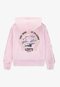Sudadera con capucha rosa con un gráfico de herradura, texto "THE WESTERN PLAINS LEVI'S 1873" y detalles fruncidos a lo largo de las mangas. Tela suave.