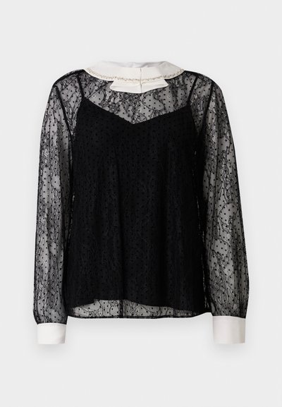 Blusa de encaje negro con mangas largas, cuello blanco con un lazo y adornos, acabado texturizado y silueta suelta.