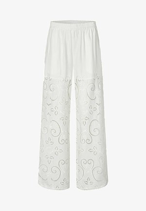 Pantalon en lin blanc avec une taille élastique, présentant des broderies florales et en tourbillon sur la partie inférieure. Design à jambe large.