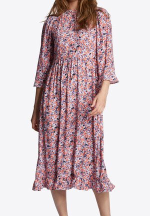 Vestido midi floral con mangas cortas abullonadas, cuello redondo y dobladillo acampanado. La tela es ligera y presenta un patrón floral multicolor.