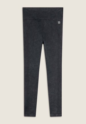 Leggings neri con una finitura testurizzata, dotati di una vita alta e cuciture laterali a contrasto. Design versatile per l'abbigliamento attivo.