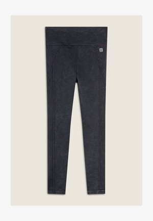 Leggings neri con una finitura testurizzata, dotati di una vita alta e cuciture laterali a contrasto. Design versatile per l'abbigliamento attivo.