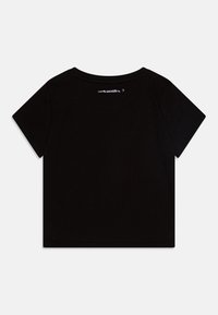 Svart kortärmad T-shirt i mjuk bomull med rund halsringning och korta ärmar. Visar logotyp på baksidan nära kragen.