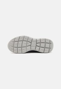 Gray rubber sole with a textured, multi-pattern tread design. Rounded shape, solid structure, and slight curvature at the toe area.