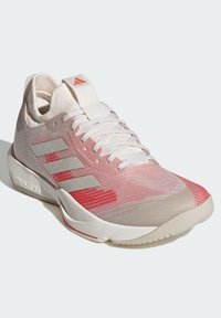 Zapatilla deportiva ligera en rosa y blanco, con una parte superior texturizada, tres franjas blancas y una suela de goma, que presenta un sutil diseño de degradado.
