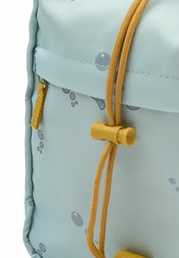 Svetlo modra nahrbtnik z teksturirano tkanino, okrasnimi mehurčki in zlato vrvico z plastičnim zatičem za varno zapiranje.
