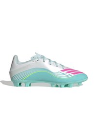 Chaussure de football blanche et turquoise avec des bandes roses inclinées et des lignes courbes, équipée de crampons moulés pour jouer sur terrain ferme.