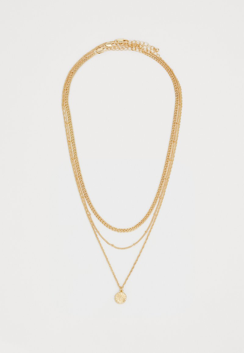 Aukso daugiasluoksnė kaklo grandinėlė, pasižyminti įvairiomis grandinių stilistikomis ir apvaliu pakabuku su tekstūruotu dizainu, rodyta prieš baltą foną.