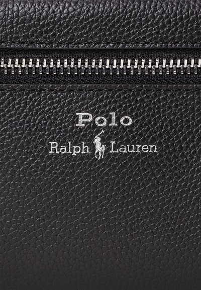 Melnas teksturētas ādas virsma ar sudraba rāvējslēdzēju un reljefa logotipu "Polo Ralph Lauren", attēlojot polo spēlētāju uz zirga.