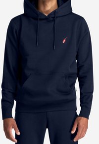 Sweat à capuche bleu marine en tissu doux, doté d'une poche frontale, d'une capuche à cordon de serrage et d'un petit logo rouge avec un accent vert.
