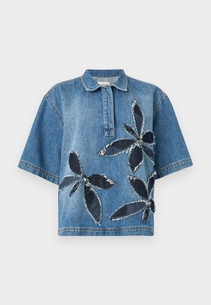 Modrá crop top košeľa z denimu s golierom, zdobená veľkými kvetovými aplikáciami z tmavého denimu a ošúchanými okrajmi pre textúru.