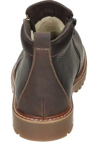 Bottine en cuir marron avec surface texturée, design épuré et couture contrastée. Dispose d'une fermeture éclair et d'une semelle en caoutchouc.