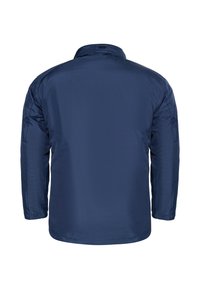 Tamsiai mėlyna, ilgomis rankovėmis striukė su glotnia, lengva medžiaga. Turi klasikinį apykaklę ir tiesų kirpimą su minimaliais akcentais.