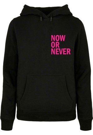 Black hooded sweatshirt featuring a front pocket, with bold pink text "NOW OR NEVER" on the left side. Cotton blend material.
