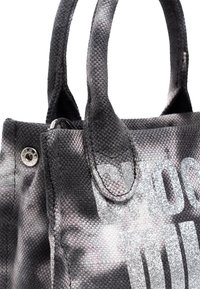 Borsa nera e grigia con texture e scritte argentate lucide. Presenta manici corti e una chiusura a scatto. Il tessuto ha un motivo sottile.