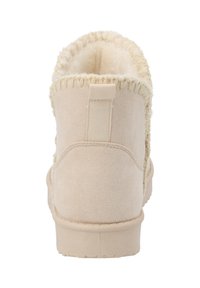 Botín de ante beige hasta el tobillo con un interior texturizado y esponjoso, y un detalle de costura alrededor del cuello. Presenta una lengüeta para facilitar su colocación.