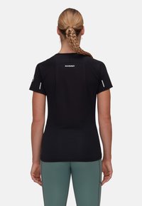 Svart kortärmad träningsskjorta med en slät textur, med en logotyp på övre delen av ryggen och reflekterande detaljer på ärmarna.