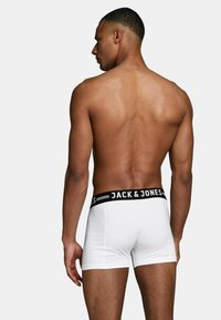 White boxer briefs with a black elastic waistband featuring the text "JACK & JONES" displayed prominently. Smooth fabric and fitted design.